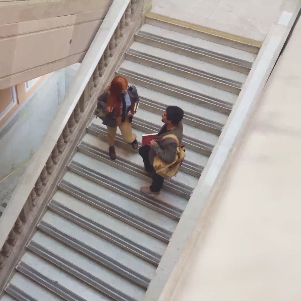 Two investors talking on a marble staircase